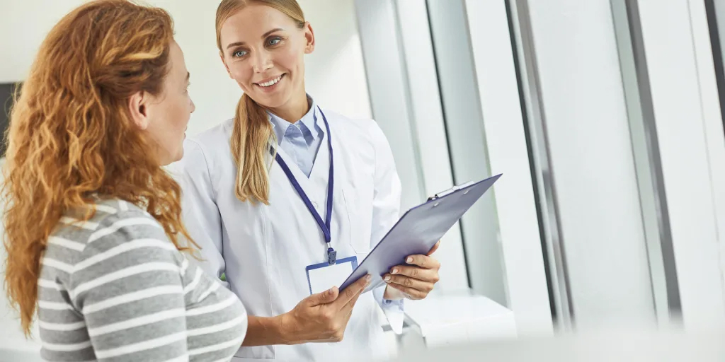 woman doctor smiling and talking to patient